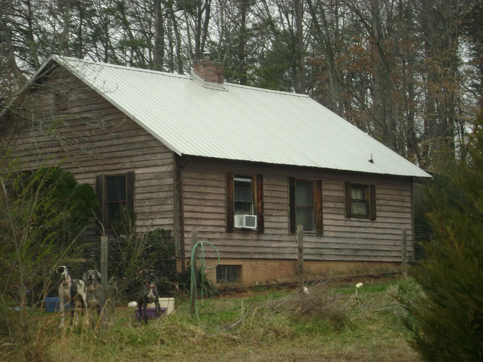 White metal roof on an old wood sided farmhouse, from a Metal Roof Installation job in Cave Creek